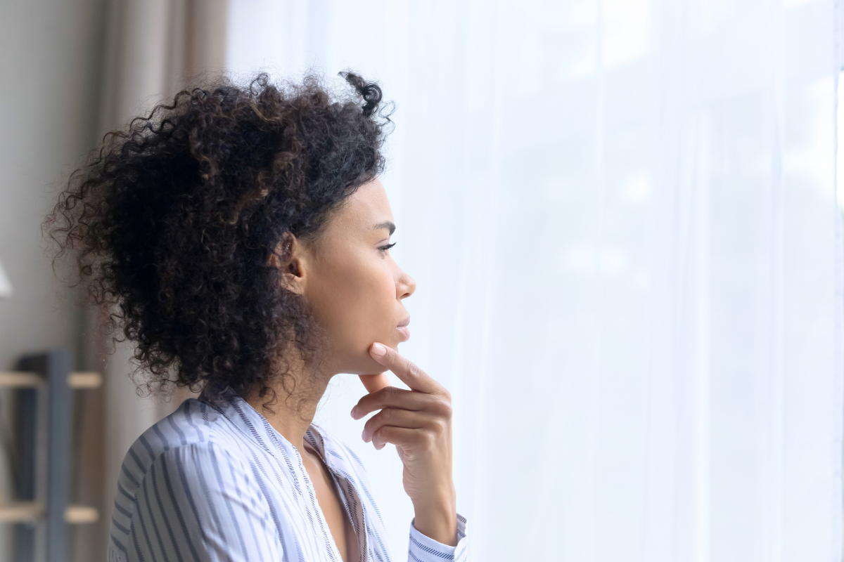 Woman gazing out a window experiencing dissociation due religious indoctrination