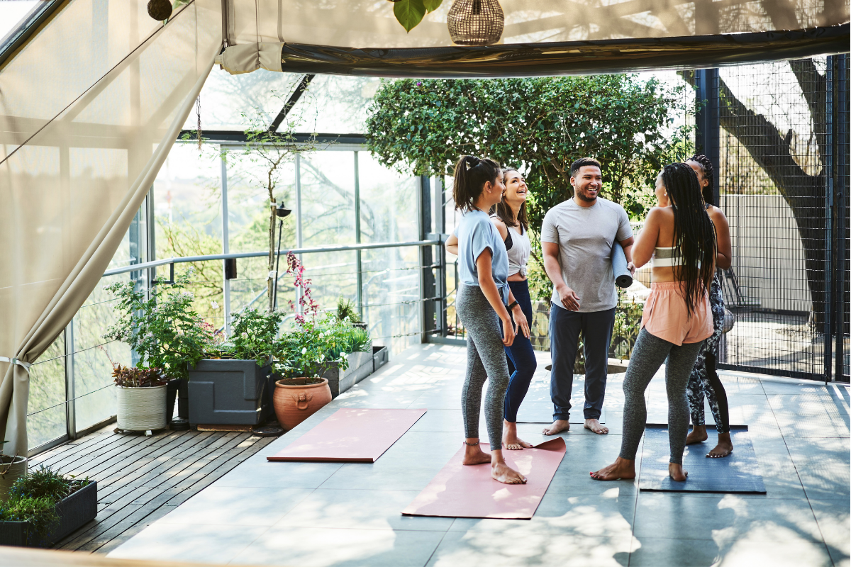 a group of people standing around each other after yoga and engaging in spiritual bypassing