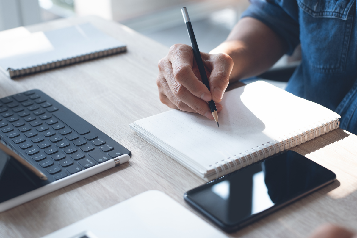 a person writing on a notebook
