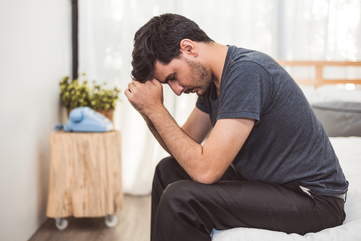 Man sitting at edge of bed wondering how religious trauma is affecting his nervous system